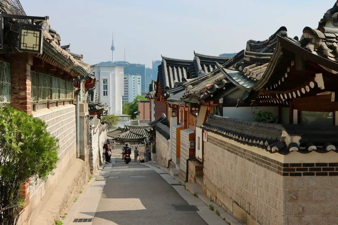 Traditional hanok roofs along a narrow street in Bukchon, Seoul