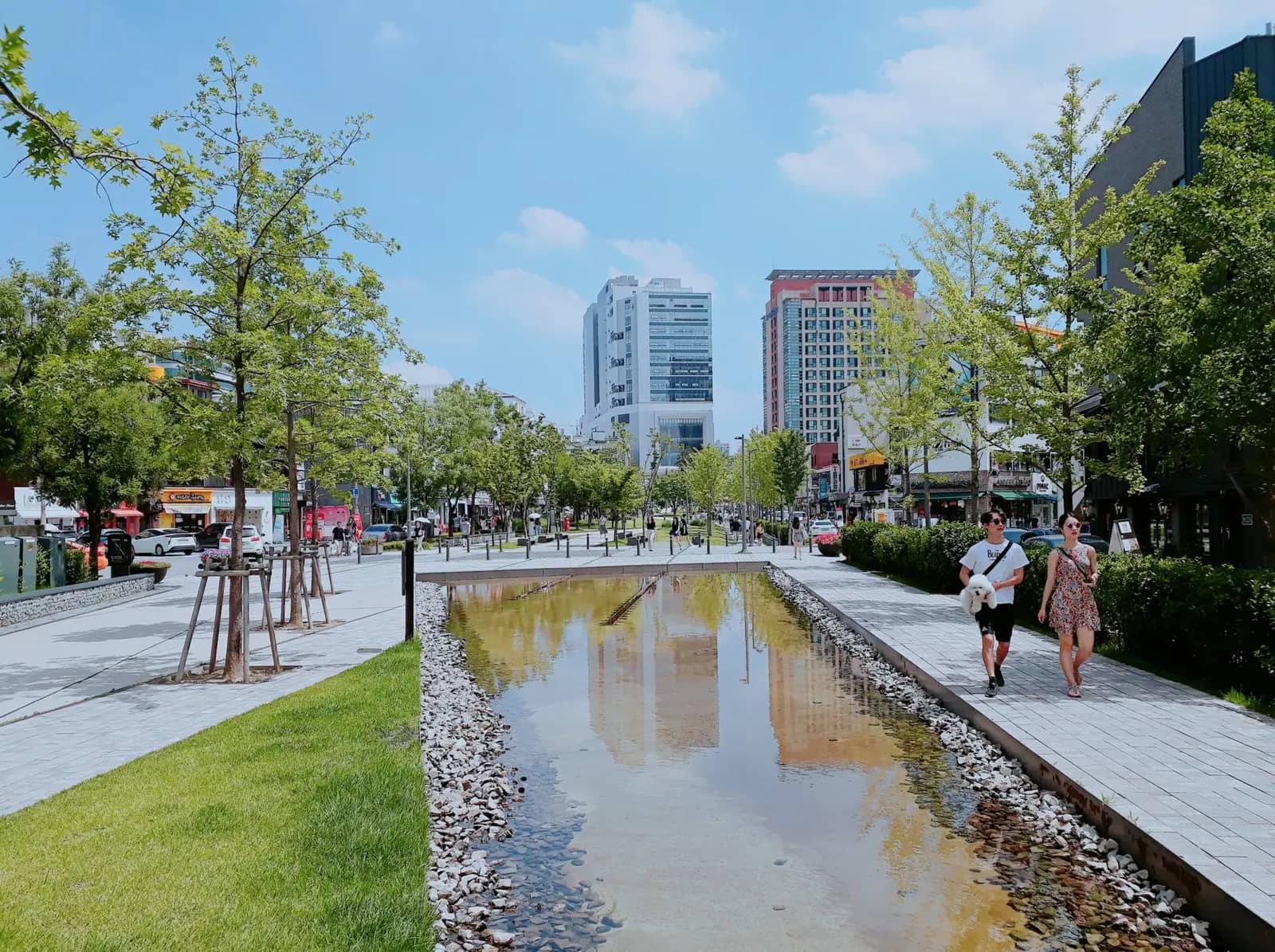Gyeongui Line Forest Park in Yeonnam-dong with a shallow water channel, lawn and young trees