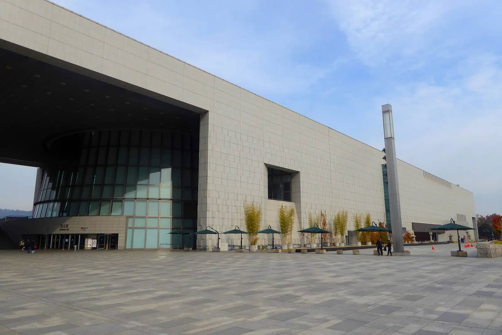 青空の下、国立中央博物館の長い石造りの外観と開けた広場