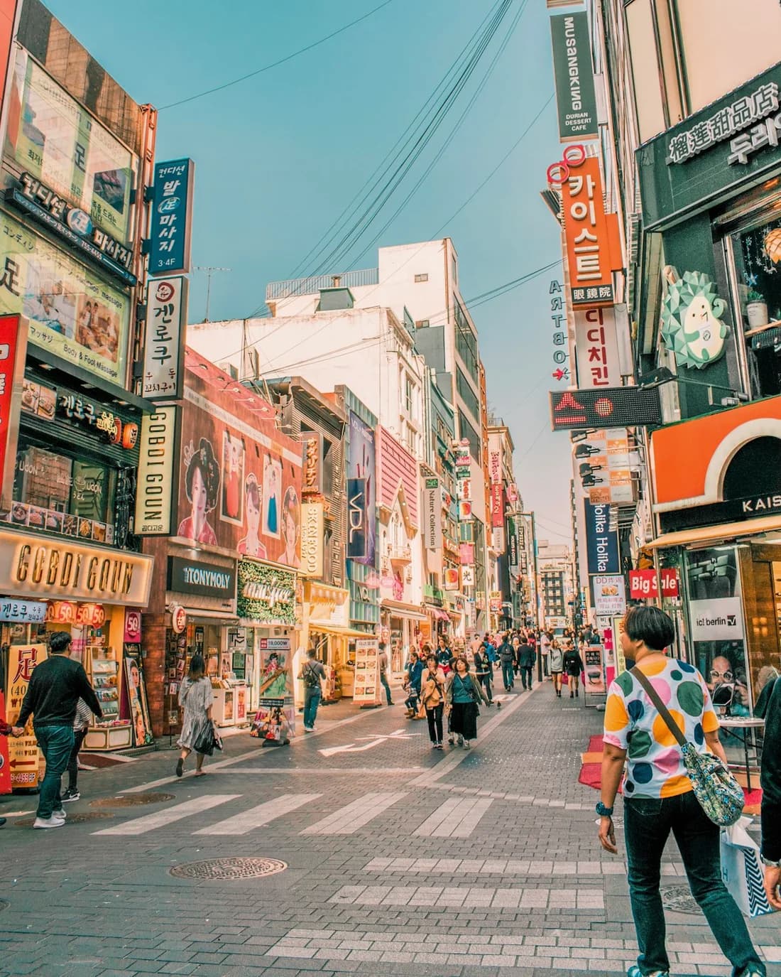 Shop signs and pedestrians on a Myeongdong street in Seoul