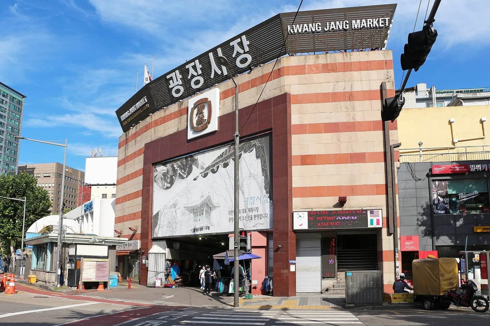 Striped entrance building of Gwangjang Market in Seoul under a blue sky