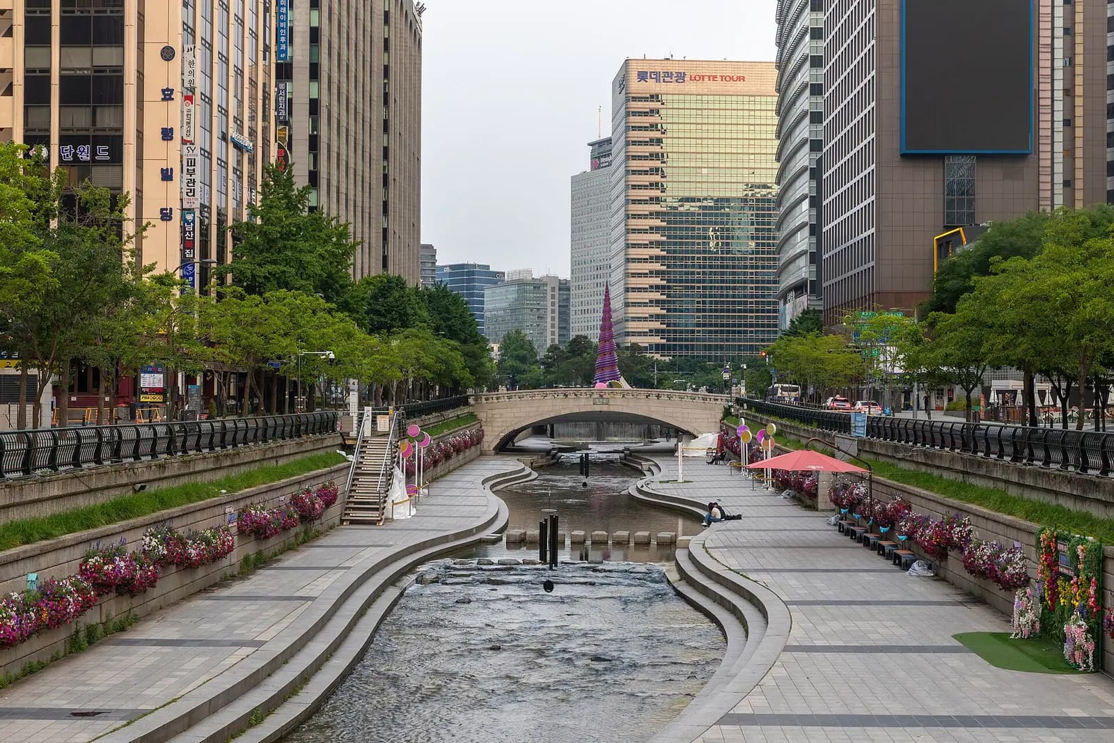 Cheonggyecheon stream running between stone walkways and office towers near Cheonggye Plaza