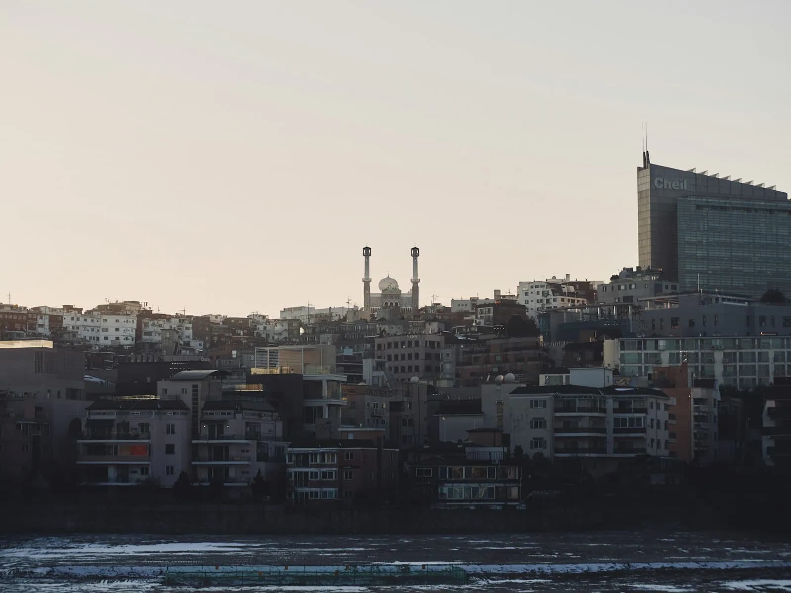 Minarets of Seoul Central Mosque above the low rooftops of the Itaewon hillside at dusk