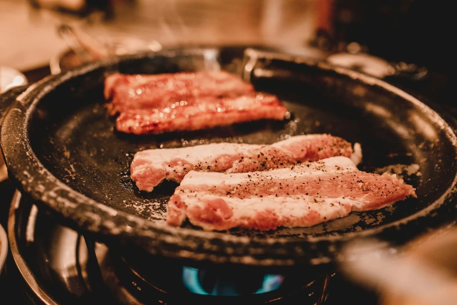 丸い韓国式の焼肉用鉄板で焼かれるサムギョプサル