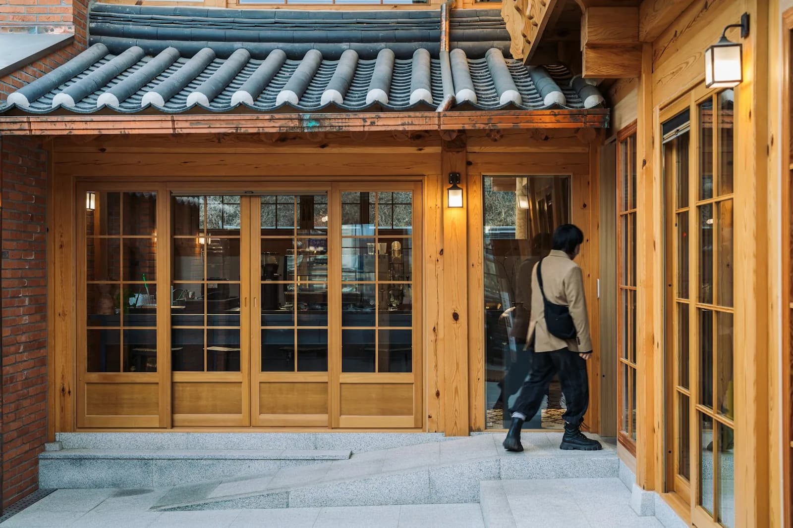 Entrance of a hanok cafe with wooden glass doors under a tiled roof