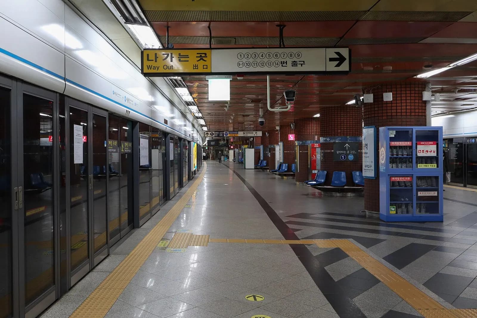 首尔站4号线地铁站台，黄色出口指示牌上列着出口编号