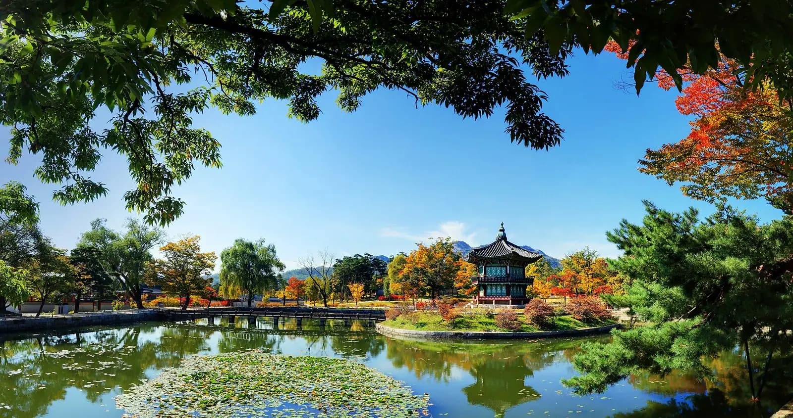 赤やオレンジの紅葉に囲まれた、景福宮の池に建つ香遠亭