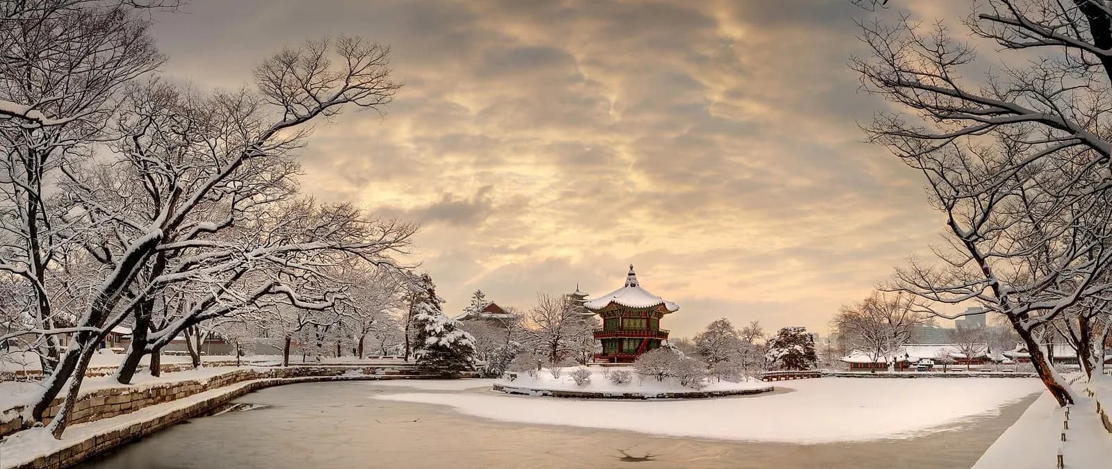 Snow-covered Hyangwonjeong pavilion and frozen pond at Gyeongbokgung Palace at dawn