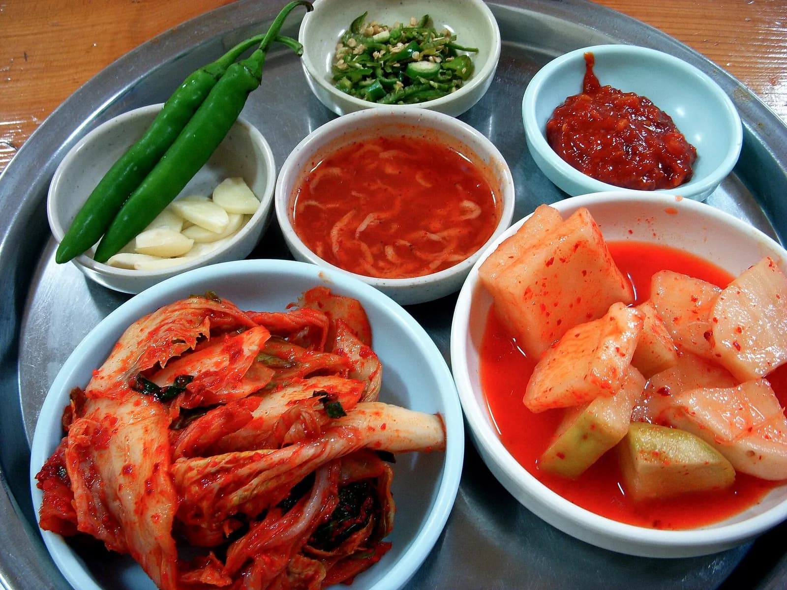 Tray of cabbage kimchi, cubed radish kimchi, jeotgal, garlic and green chilies