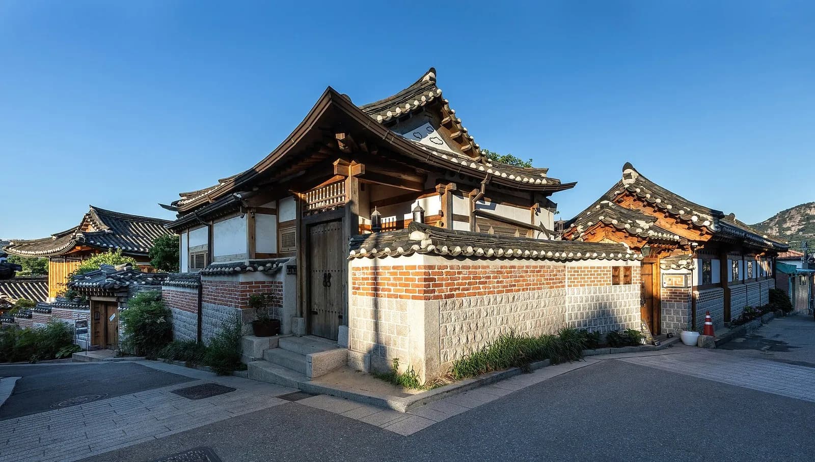 Traditional hanok houses with tiled roofs and brick walls in morning light in Bukchon Hanok Village, Seoul