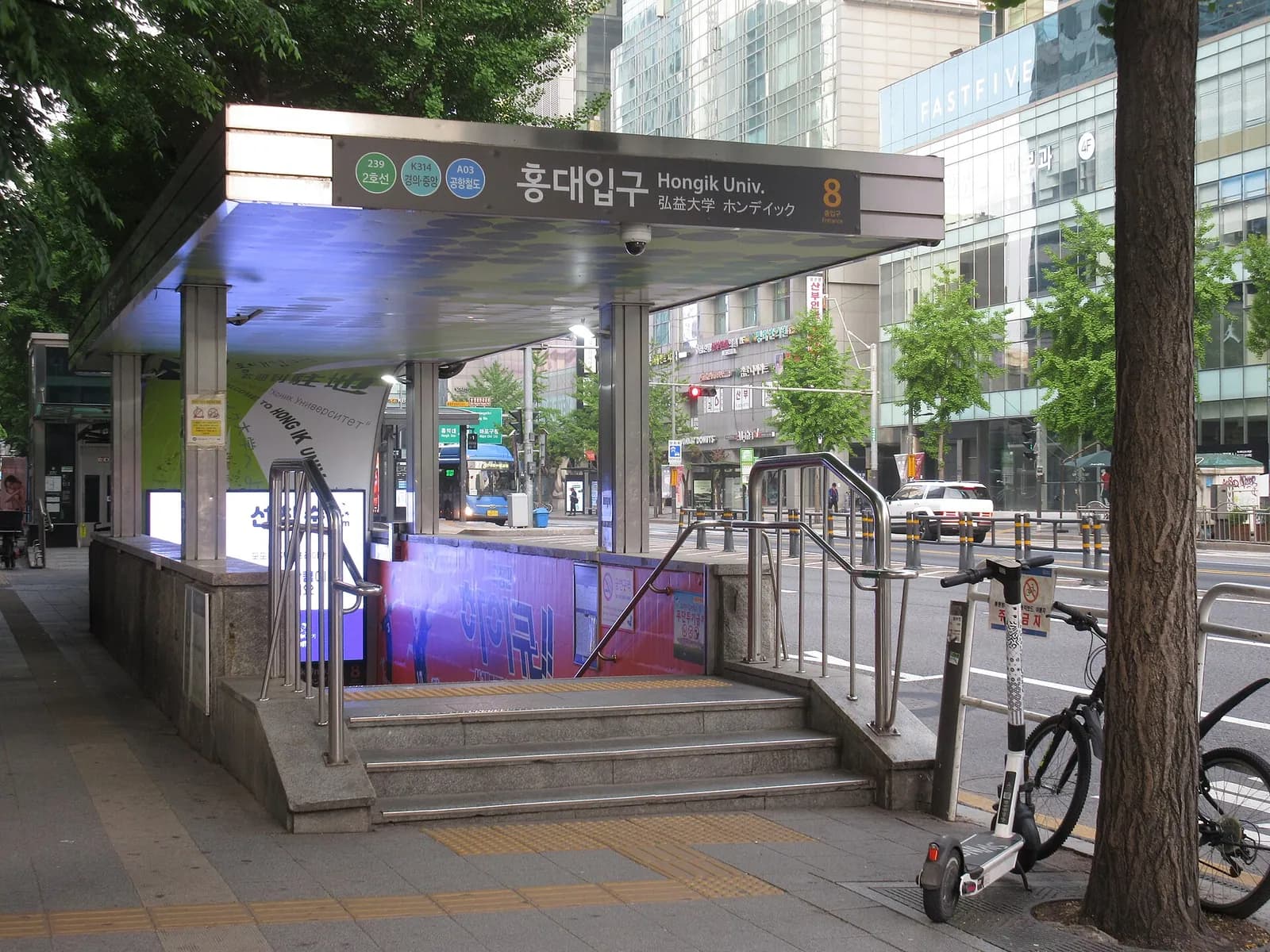 屋根に出口番号が表示された、ソウルの弘大入口駅8番出口の地上入口