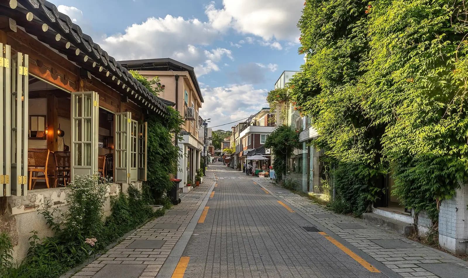 Gyedong-gil street in Bukchon with an open-window hanok cafe and ivy-covered wall